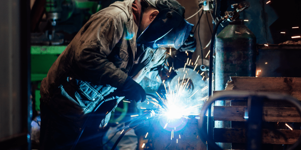 A man welding is empowered by knowing his organisation benefits from Operation Learning.